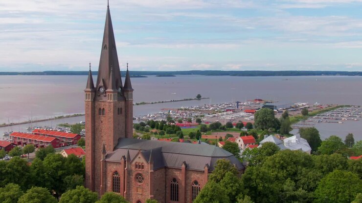 Immagini aeree maestose di una chiesa che si avvicina a Mariestad, in Svezia, rivelando acque meravigliose e un porticciolo