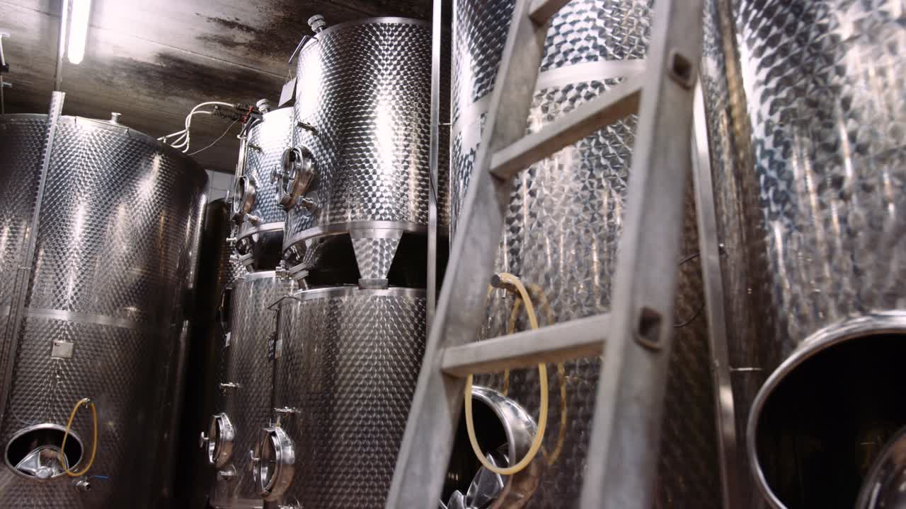 tanques de acero inoxidable brillante en bodega utilizados para la fermentación del vino, inclinación hacia arriba