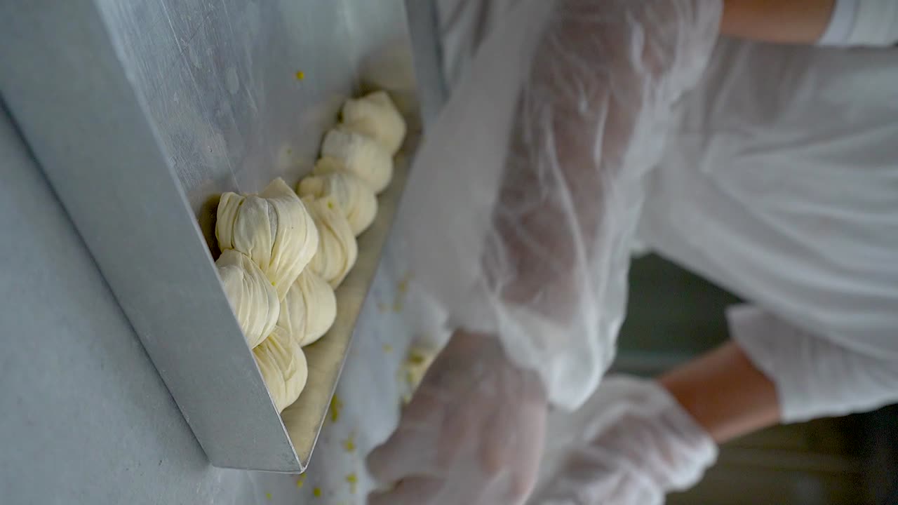 The Turkish pastry chef places pieces of oyster baklava in the tray
