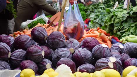 market stall with red cabbage, carrots, and lemons