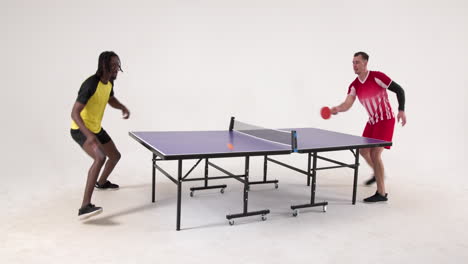 multiracial male table tennis players serving and passing the ball to each other on white background