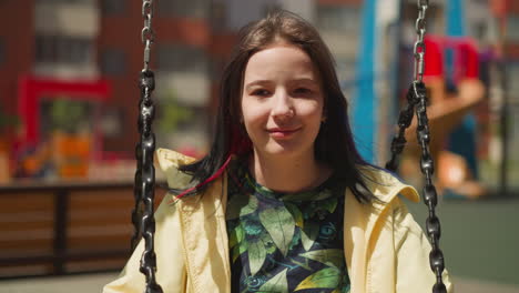 dreamy teenager closes eyes fantasizing sitting on swing