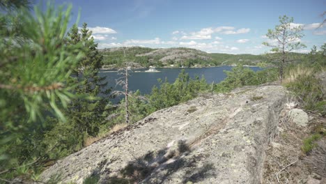 Beautiful-remote-Norwegian-fjords-in-summer,-slider-shot-behind-rocky-cliff