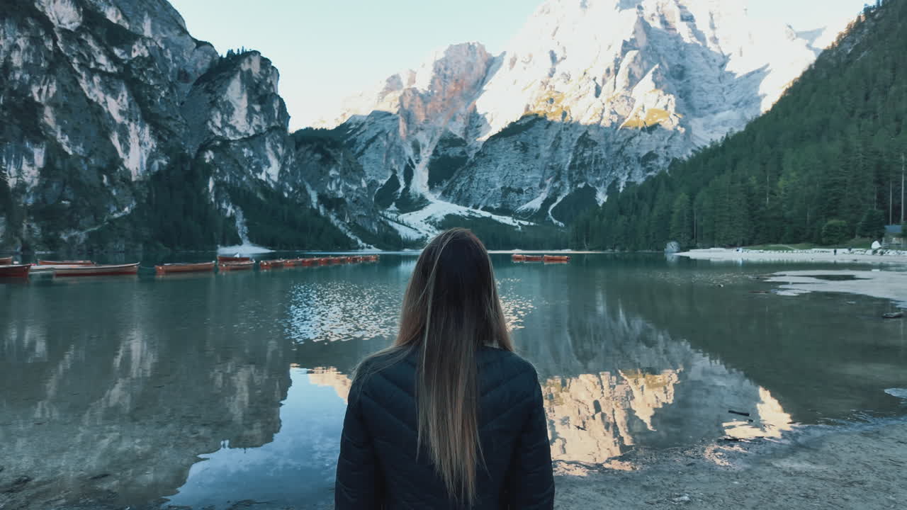 Woman enjoying the breathtaking view of Lago di Braies and the Dolomites
