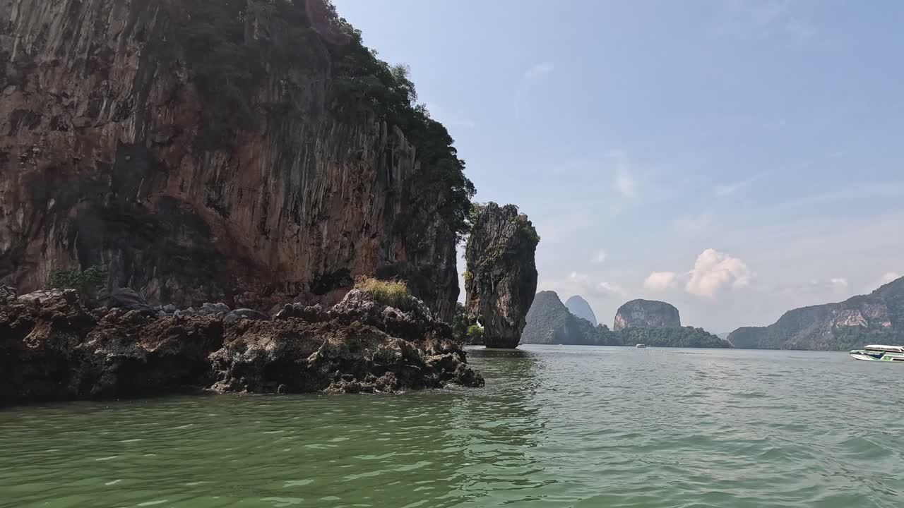 높은 절벽 을 가로질러 푸른 물 을 타고 보트 를 타고