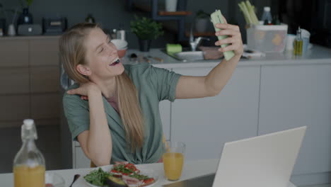 Woman having breakfast and video calling in the kitchen