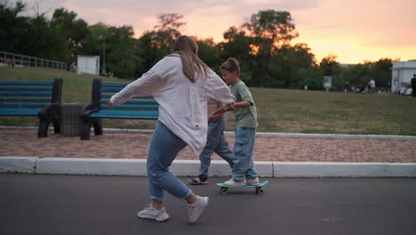 family and friends skateboarding in the park at sunset