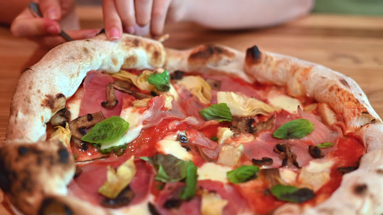 Donna che mangia una grande pizza in un ristorante italiano