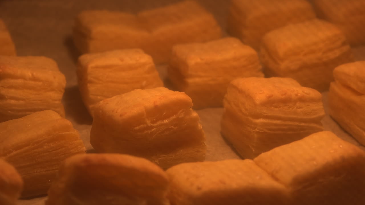 Cottura di scones di pasta sfoglia nel forno in cucina, filmato in time-lapse con messa a fuoco selettiva.