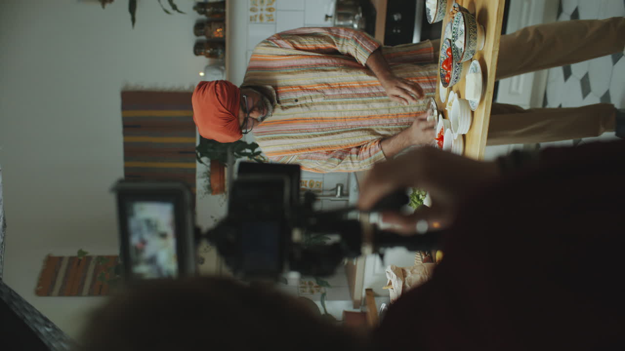 chef indio en turbante siendo filmado en la cocina para el programa de cocina