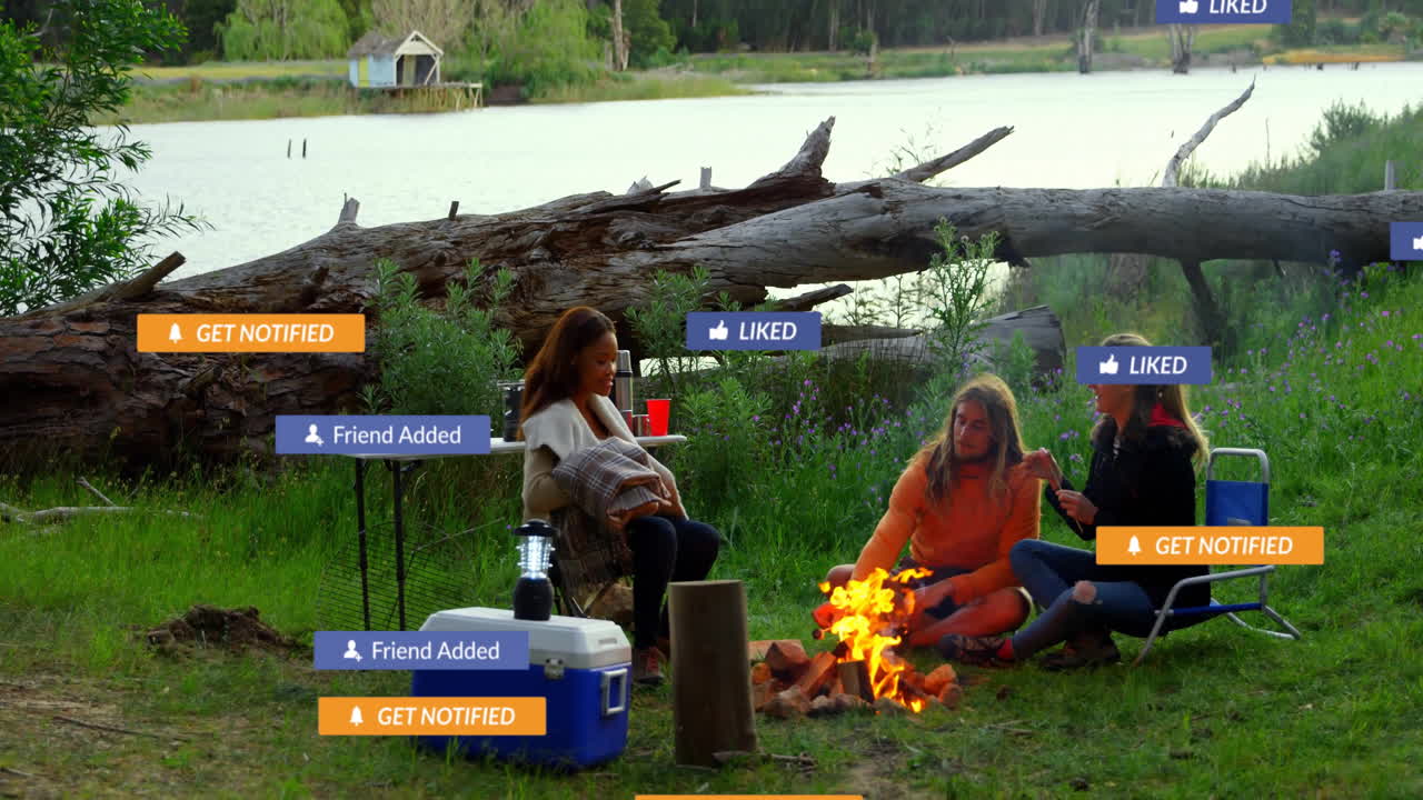 Around campfire, people engaging with animation of social media notifications