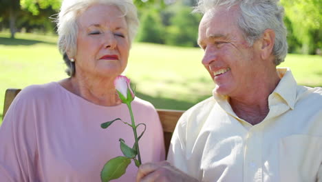 mature woman smelling a rose