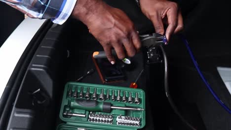 cutting electrical wire in a car or vehicle boot, preparing to install a speaker.
