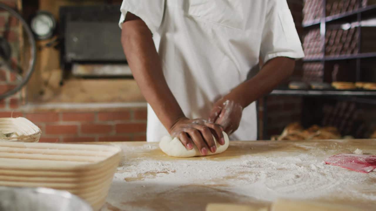Animation of midsection of african american male baker preparing sourdough for bread
