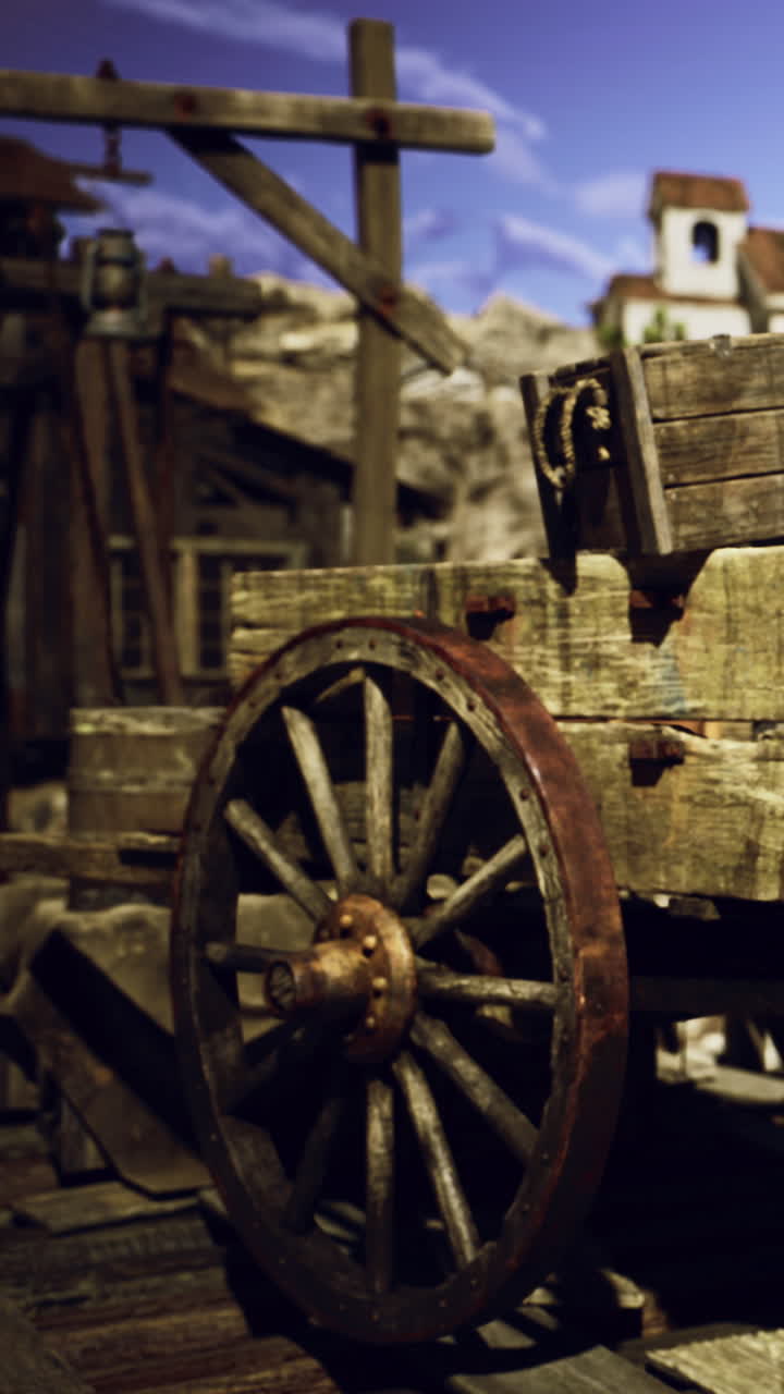 Vecchia ruota di carro in legno appoggiata su un terreno rustico in una scena di villaggio baciata dal sole.