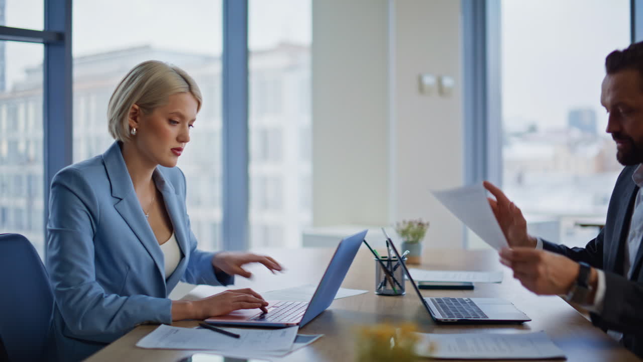 Businesswoman passing work document colleague at glass tower workspace closeup