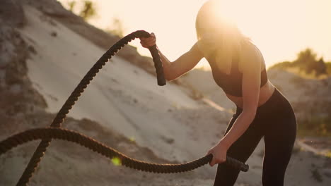 female athlete training outdoors around the sand hills at sunset. active physical activity workout. crossfit