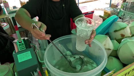 person pouring coconut water into a glass