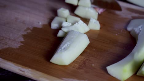 Papaya-pieces-being-cut-on-cutting-board-to-prep-for-a-meal-Green-and-ripe-yellow-organic-fresh-papaya-pawpaw