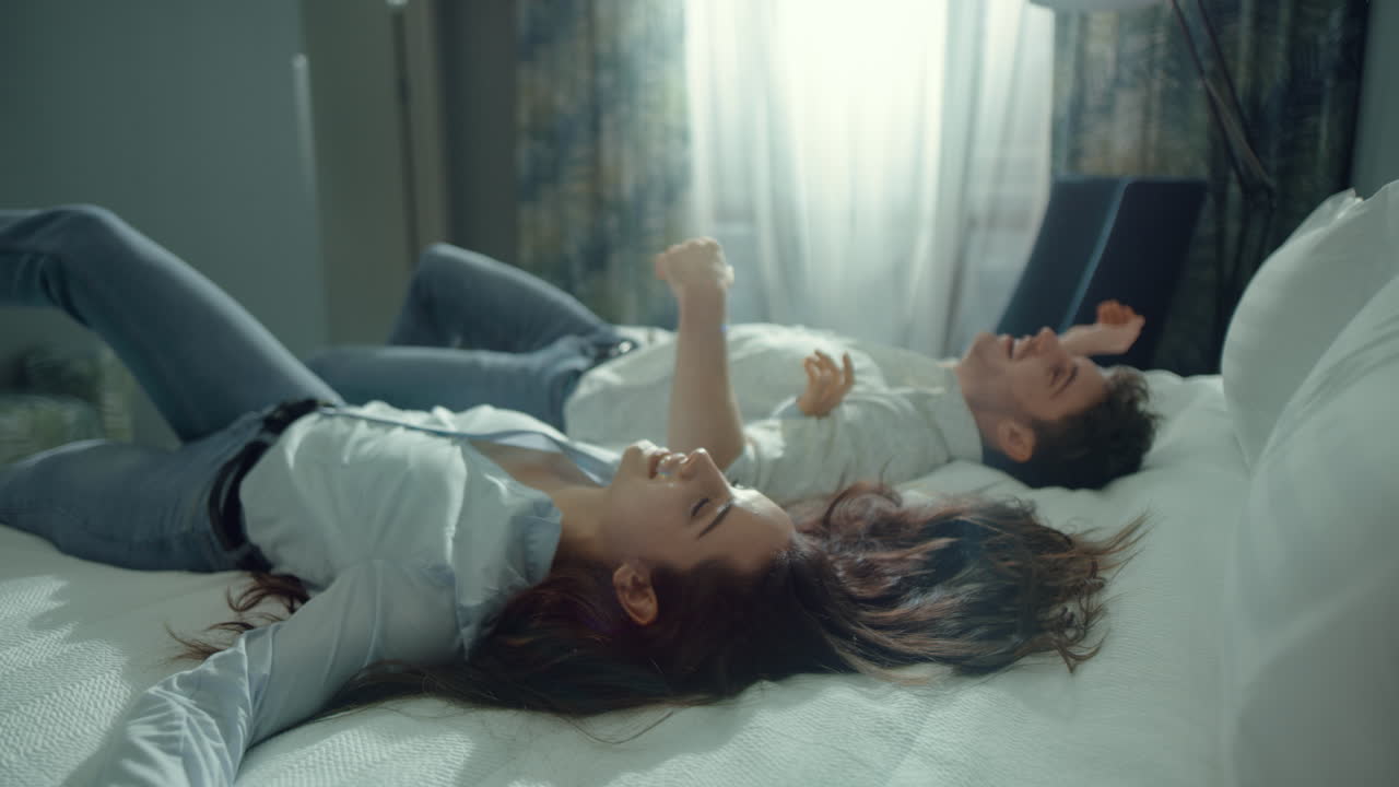매력적인 커플이 호텔 방에서 웃고 있습니다.