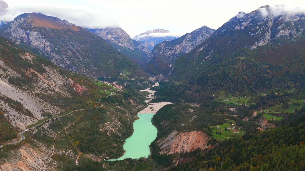 Fly above Italy’s Vajont Dam, framed by towering cliffs and tranquil water.