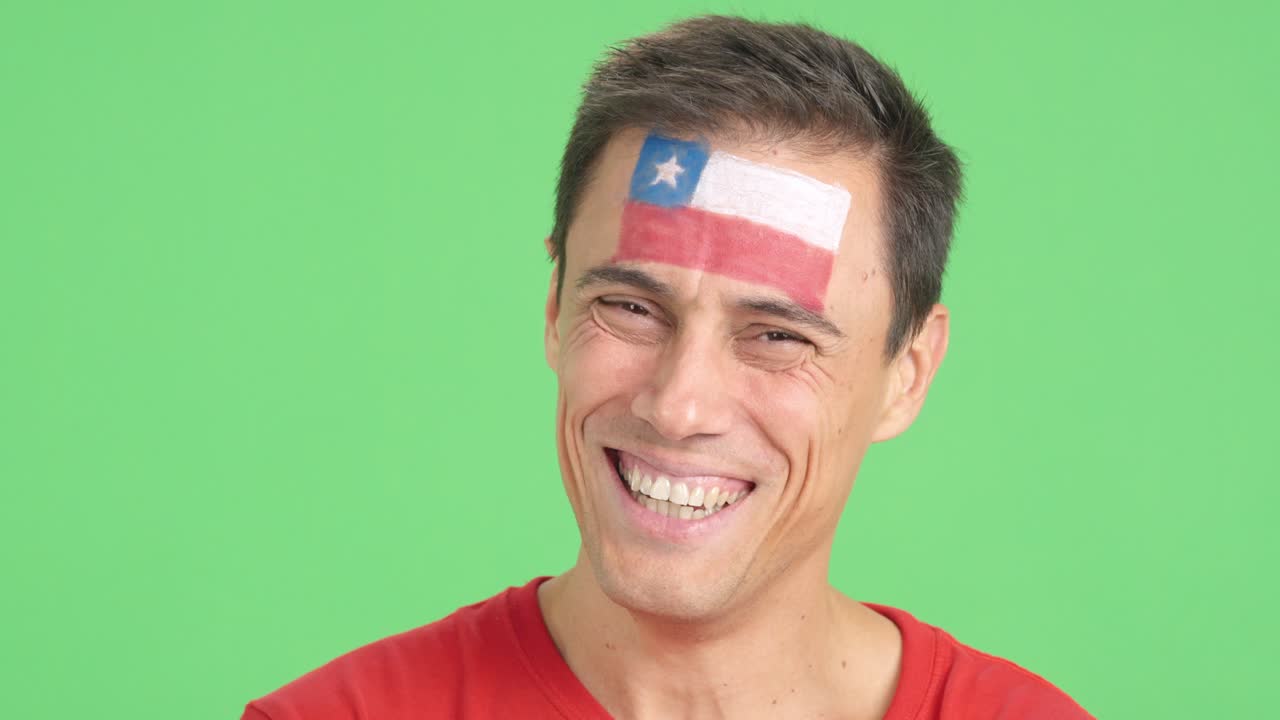 Man with a chilean flag painted on the face smiling