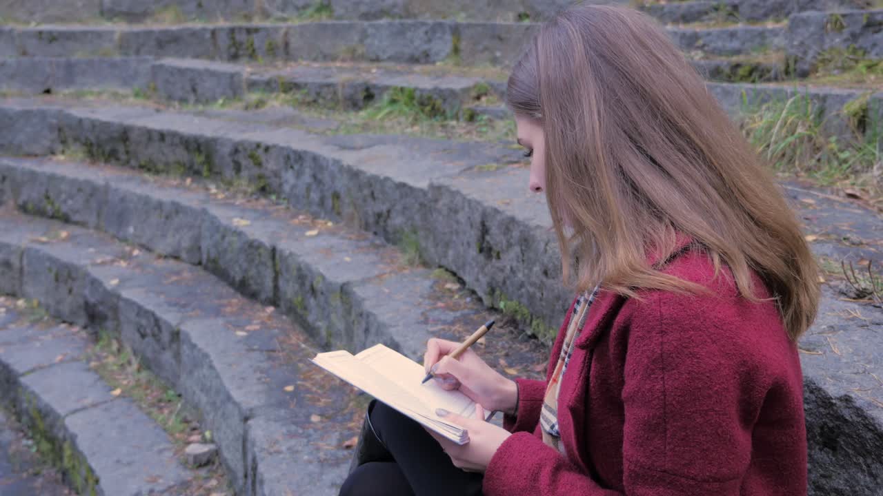 Donna che scrive in un parco