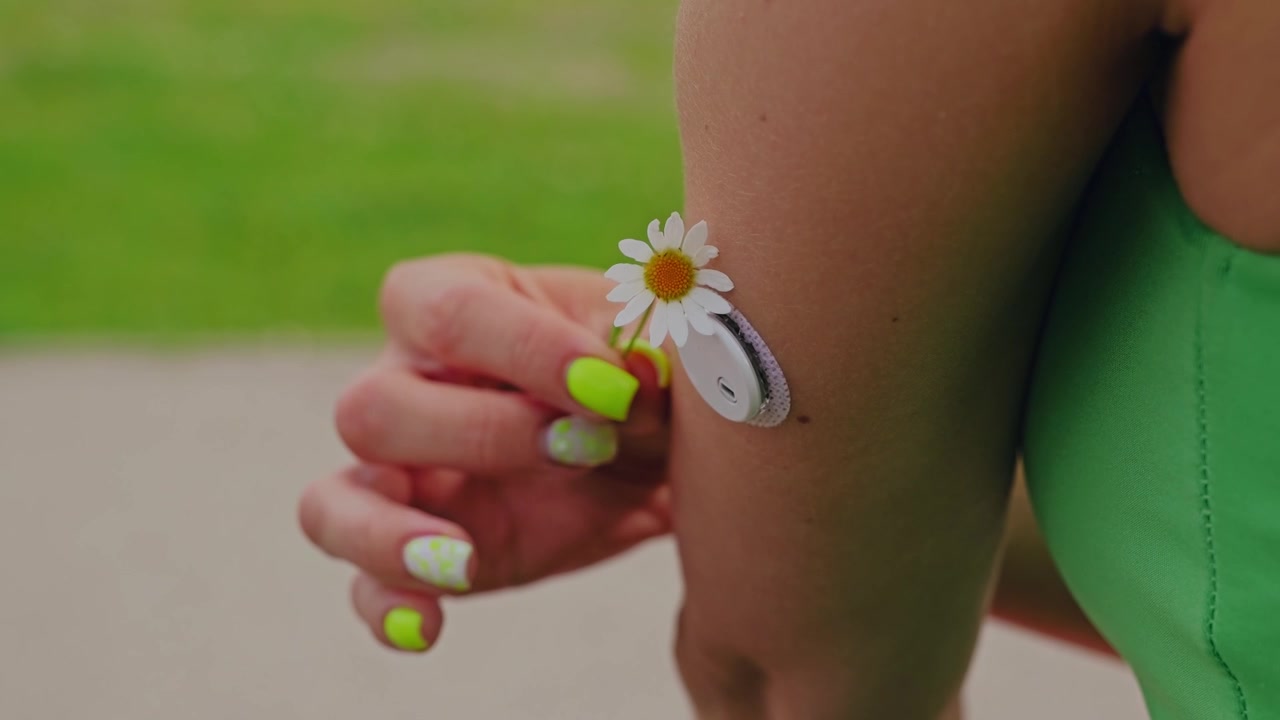 Woman with CGM sensor, Leucanthemum vulgare touching arm, AI health monitoring