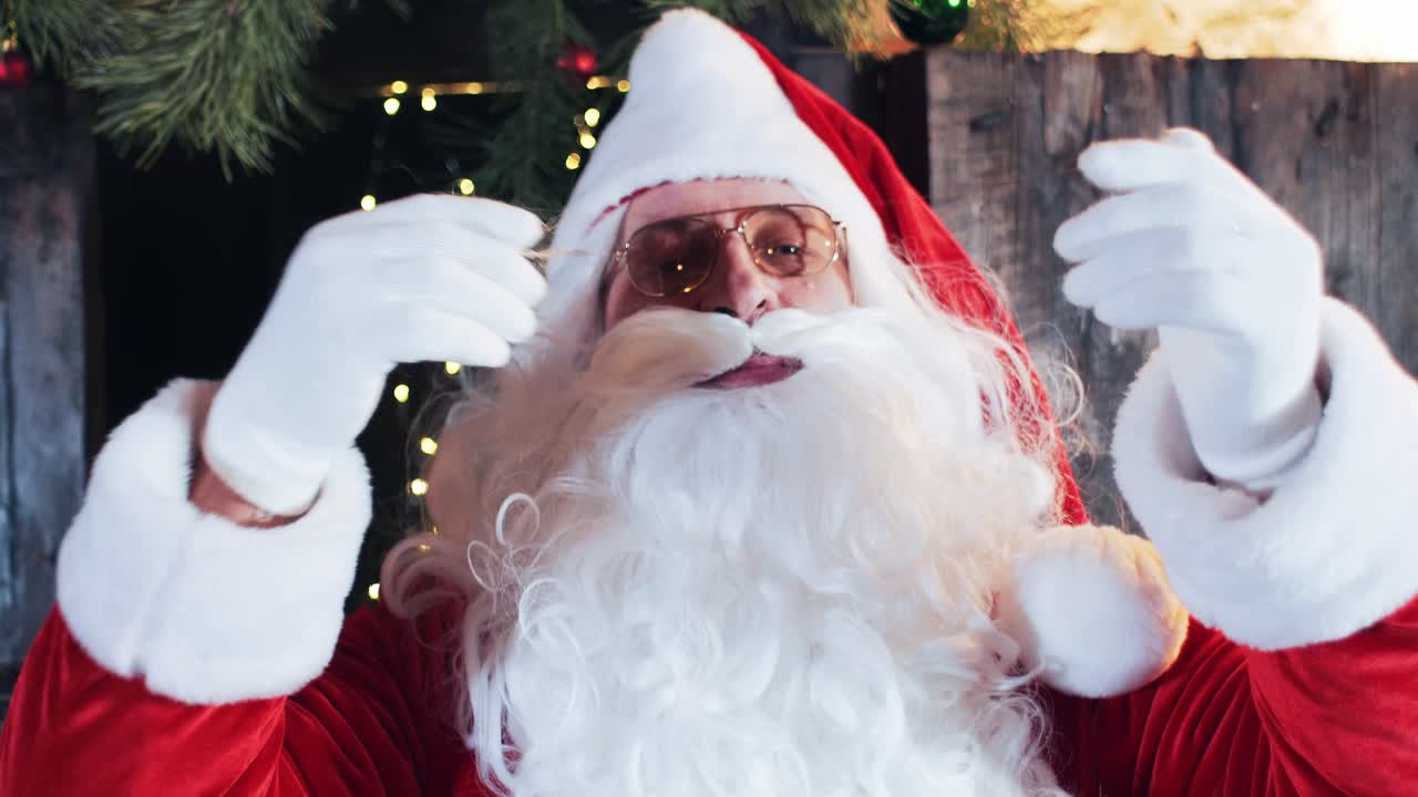 santa claus preens and straightens his white beard and mustache