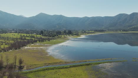 aerial perspective of aculeo lagoon in valparaíso, chile, showcasing the serene landscape, lush greenery, and tranquil water against a backdrop of mountains