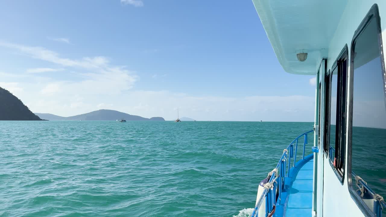 A serene boat ride across turquoise waters in Chalong Bay, Phuket, with clear skies and distant islands