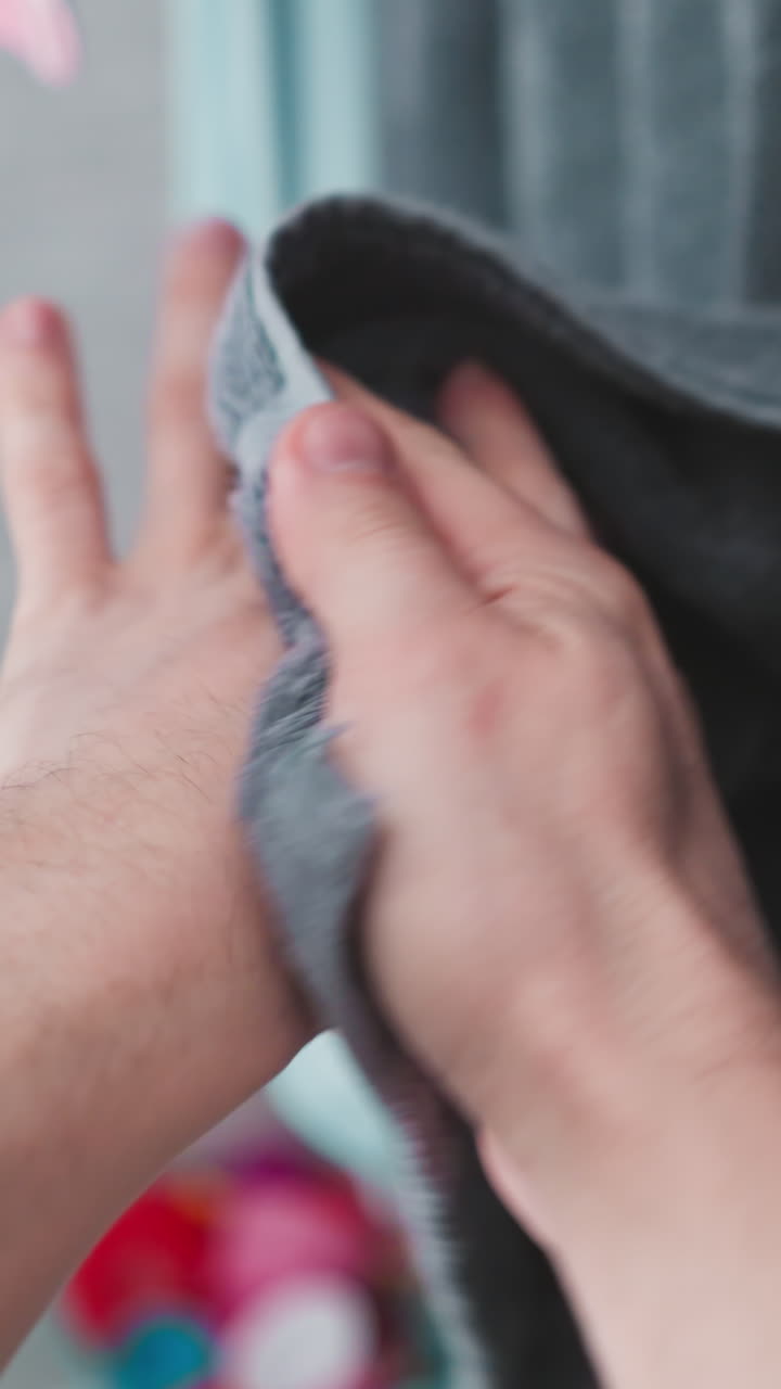 세탁 후 수건으로 손을 건조하는 모습, 가정 화장실 환경에서 개인 위생과 자기 관리에 대한 명확한 묘사