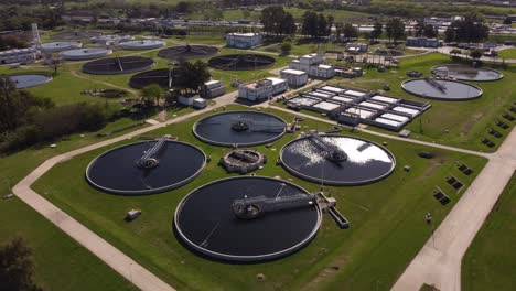 Sobrevuelo-Aéreo-Planta-De-Purificación-De-Agua-Industrial-Con-Piscinas-De-Agua-Para-La-Filtración-De-Aguas-Residuales---Luz-Del-Sol-Brillando-Dur