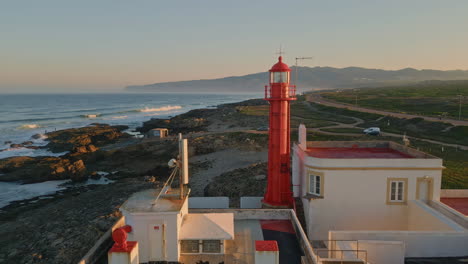 scenic morning lighthouse drone view. beautiful red beacon standing on sea shore