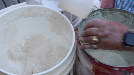 newly ground whole wheat flour scooped and moved from flour mill bin to baker's container