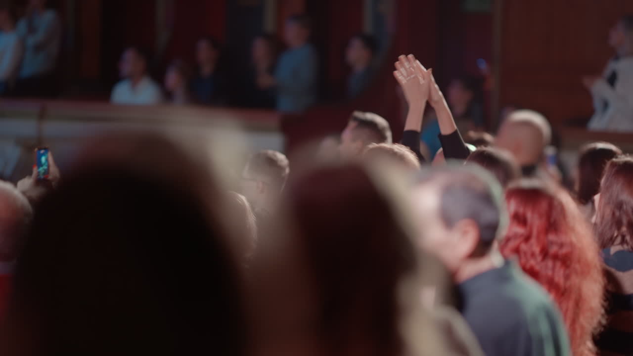 Pubblico che applaude e alza le mani a un evento dal vivo.