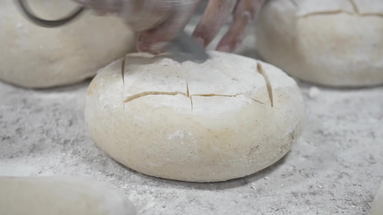 A woman rolling dough in a private bakery, captured in 4K resolution at 60fps, slow motion.