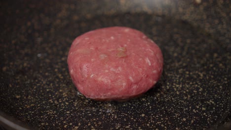 pan frying homemade beef patty. close-up shot