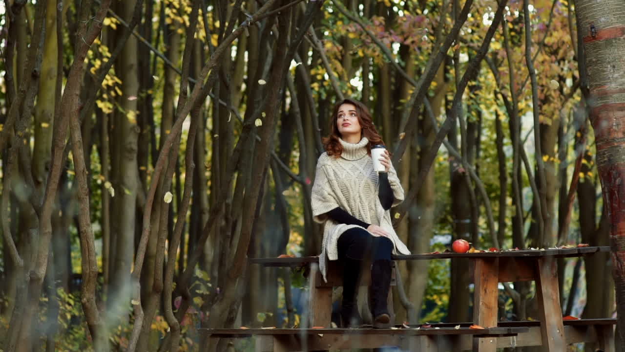 Fashion woman walking in autumn park. Outdoor fashion video of young beautiful lady surrounded autumn leaves