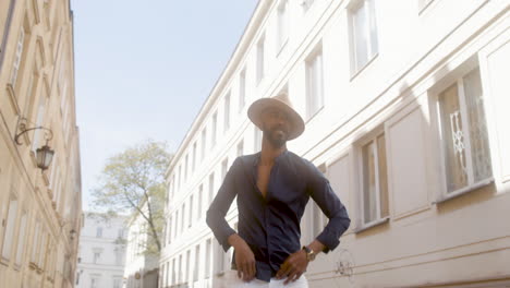 glücklicher afrokaribischer mann mit panamahut tanzt lateintanz allein in der altstadtstraße 1