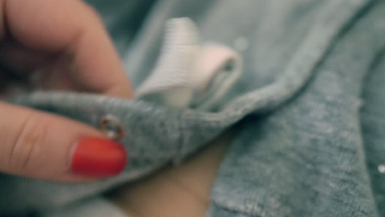 Madre che allaccia i bottoni a pressione al suo bambino.