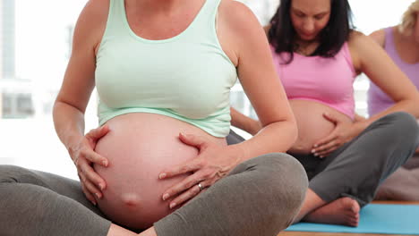 pregnant women doing yoga in fitness studio