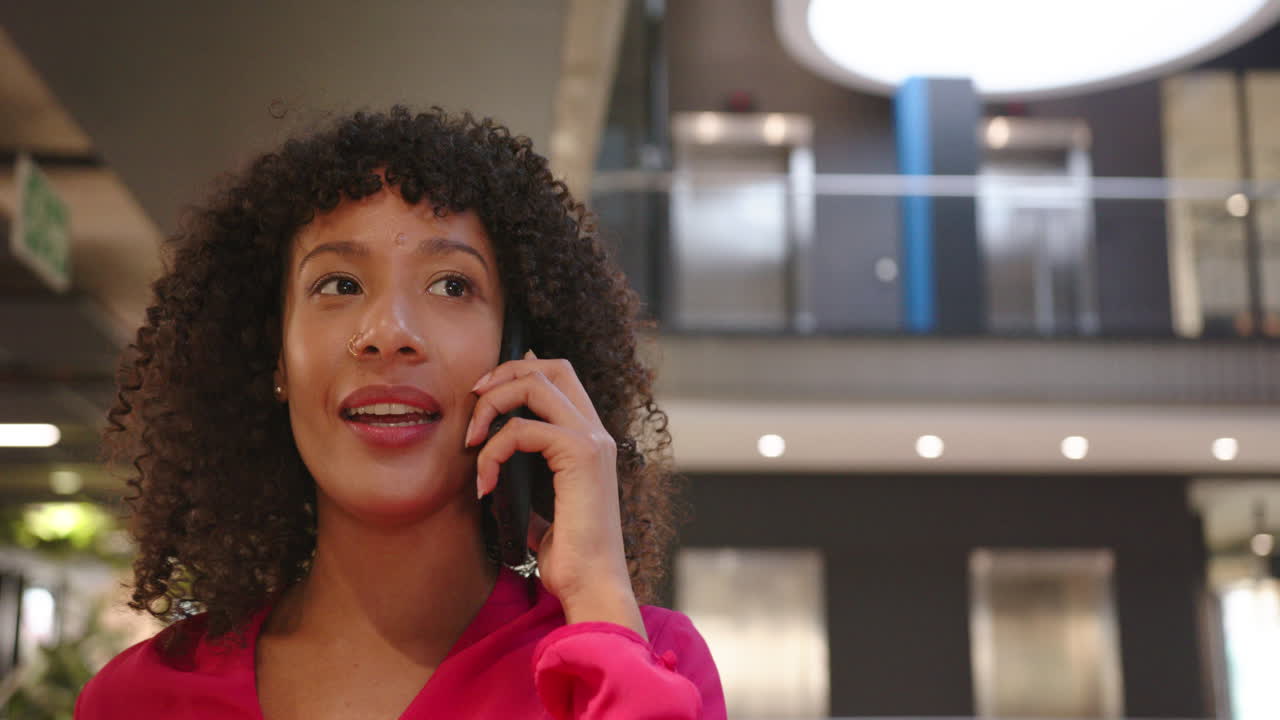 Talking on smartphone, businesswoman in office building, focusing on conversation, copy space