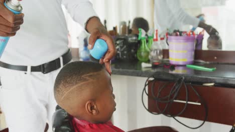 Afrikanischer-Mann,-Der-Die-Haare-Eines-Afrikanischen-Jungen-Fertigstellt