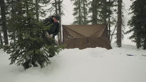 hombre construyendo refugio en una ventisca de tormenta de nieve