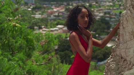 standing atop san fernando hill, a girl in a ruby dress watches the city, the coastline forming a beautiful backdrop.