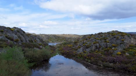 low flying drone above laguna de los garandones leon spain pond reflecting sky
