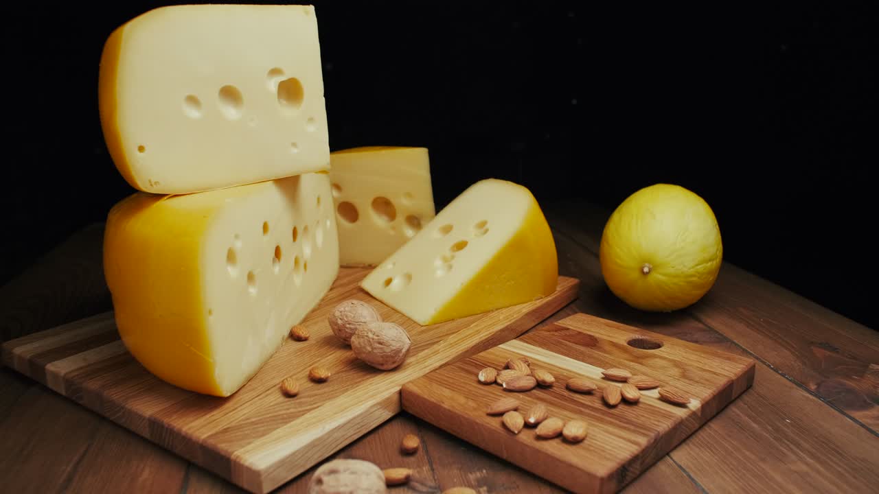 queso duro medio cabeza edam gouda parmesán en tabla de madera, con nueces y miel. tiro de diapositiva