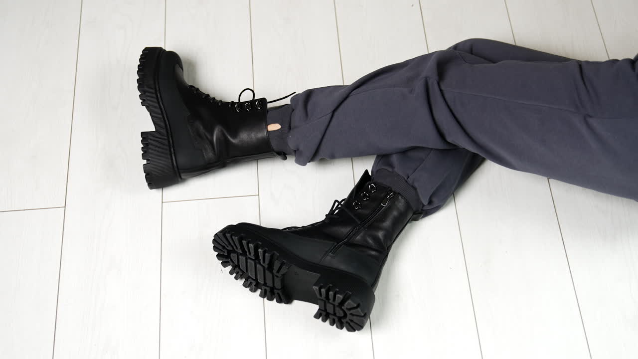 Woman wearing black chunky boots and grey sweatpants