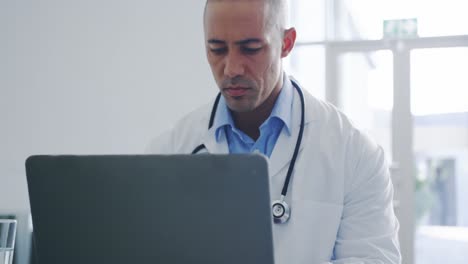 médico masculino usando una computadora portátil en la oficina 4k